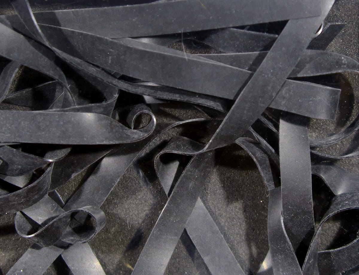 Black matte synthetic nymph skins: thin flat rubbery strips curled and layered for fly tying