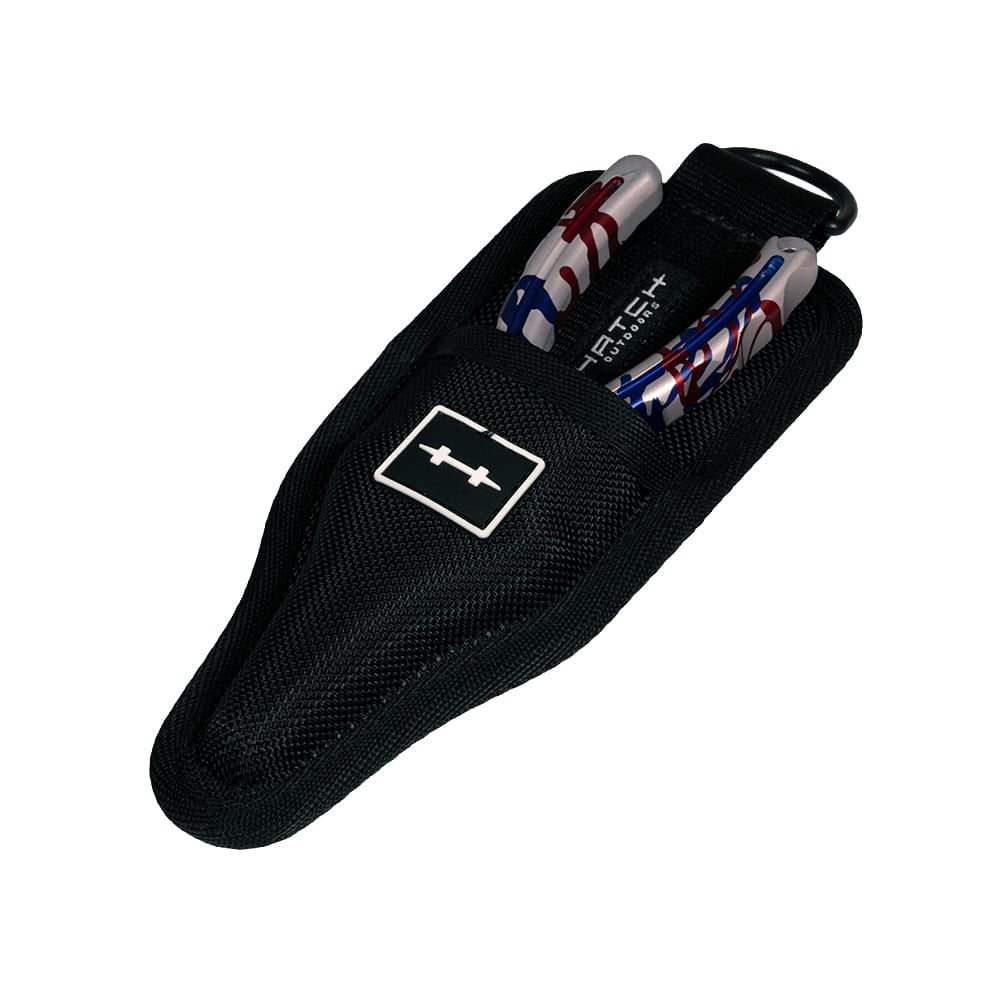 Black nylon sheath with Hatch logo holding silver Nomad 2 pliers with red, white and blue USA flag handles and keyring