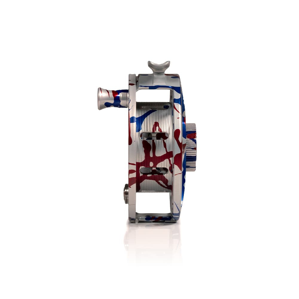 Hatch Iconic USA 250th fly reel, side profile in silver CNC aluminum with red and blue splatter paint finish