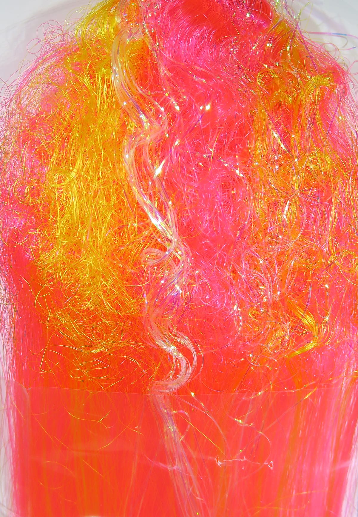 Neon pink and orange fly tying fiber with iridescent strands and clear curled filament