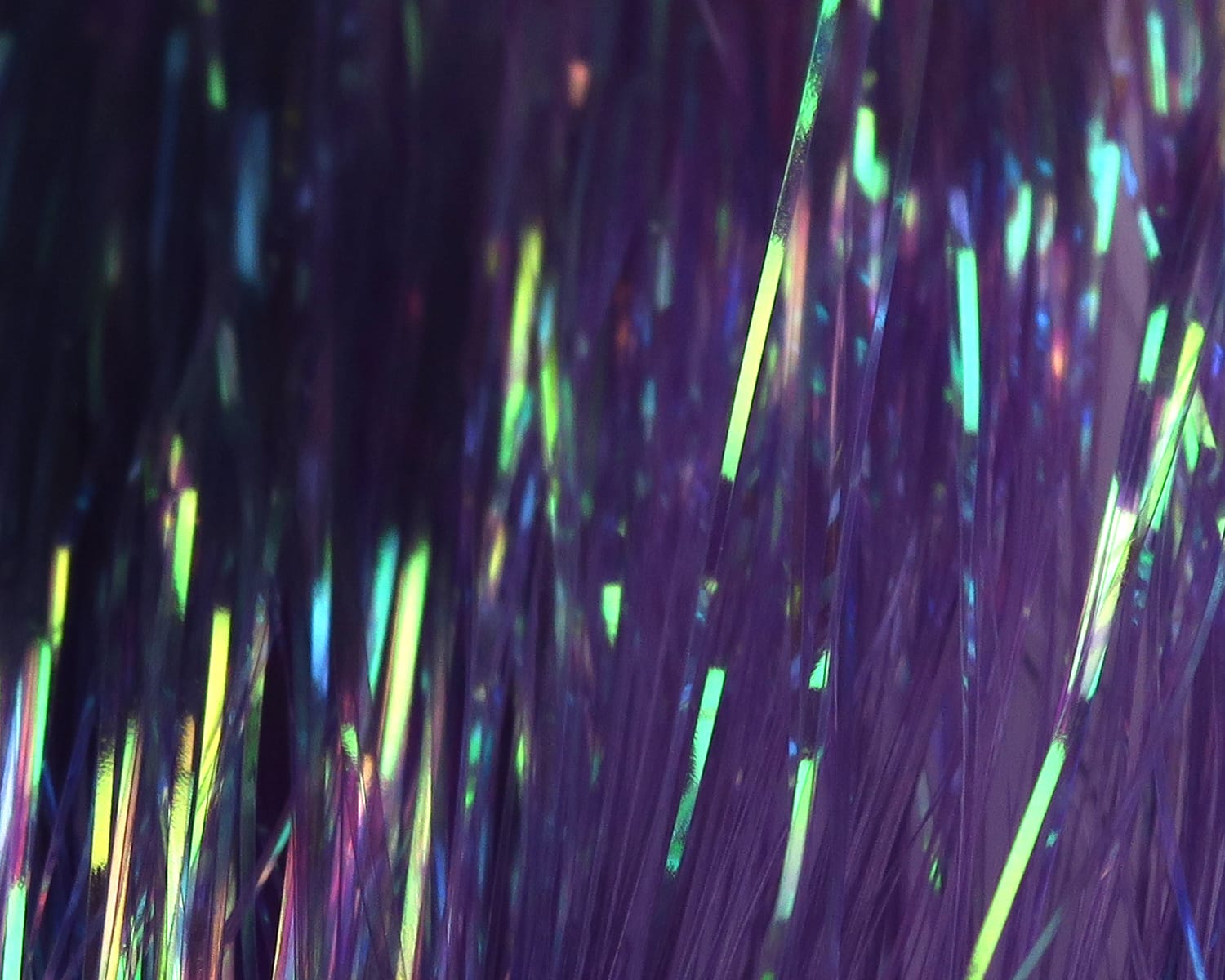 Purple dyed pearl Flashabou strands with iridescent green-yellow highlights, fine metallic tinsel for fly tying