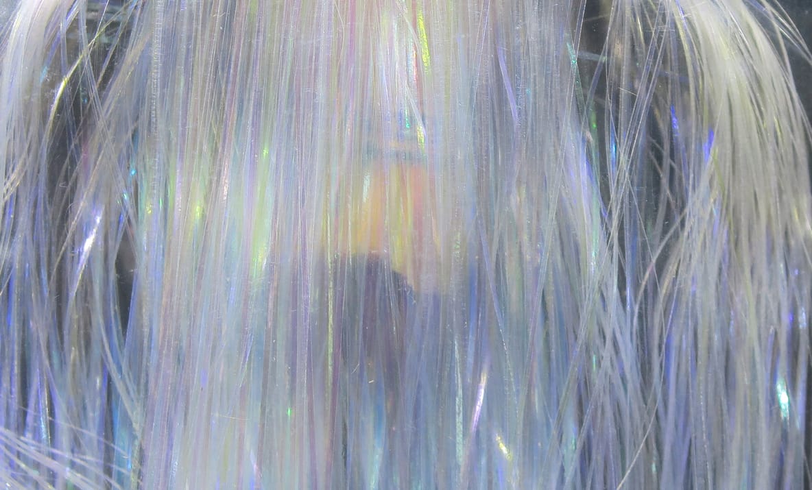 Iridescent Hedron Flashabou synthetic flash fibers in pearly white with blue, purple and green sheen for fly tying