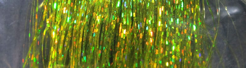 Hedron holographic Flashabou strands in chartreuse green with gold-orange iridescent tinsel for fly tying