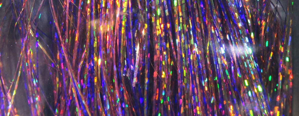 Hedron holographic Flashabou tinsel strands, iridescent purple-pink metallic fibers with rainbow flash, fly tying material