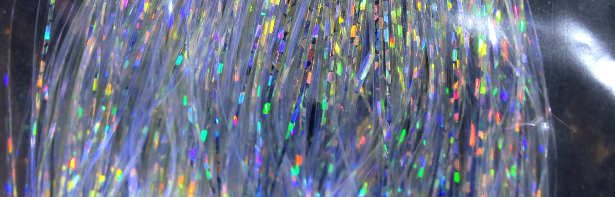 Silver translucent holographic Flashabou strands with rainbow sparkles, thin reflective fly tying material