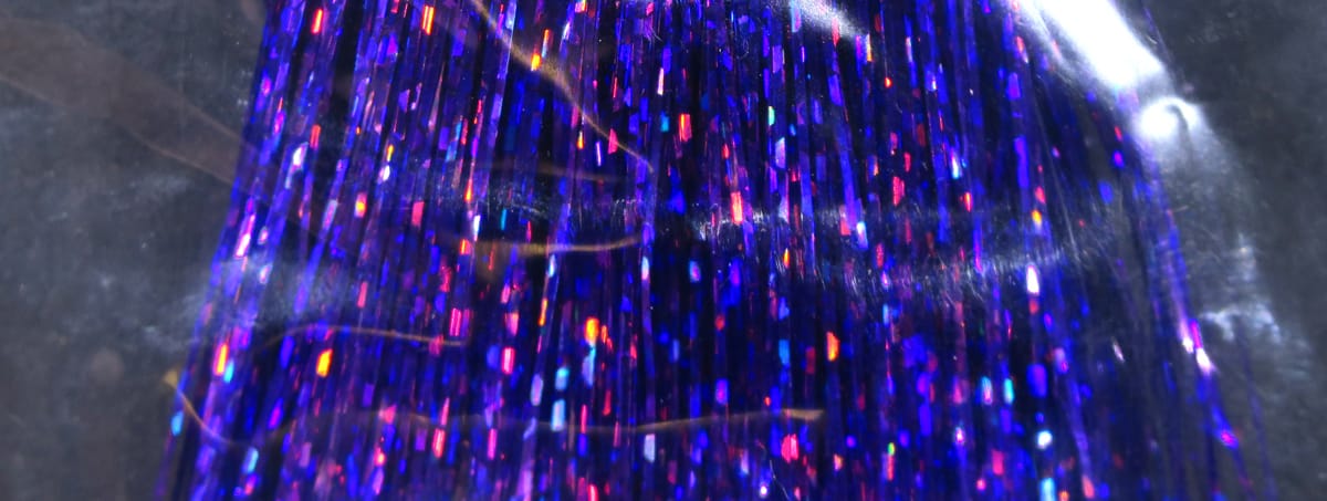 Holographic Flashabou strands in deep purple-blue with shimmering rainbow flecks, synthetic tinsel for fly tying