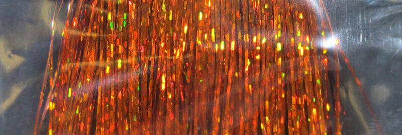 Hedron Holographic Flashabou orange-copper tinsel strands with green-gold reflective flashes for fly tying