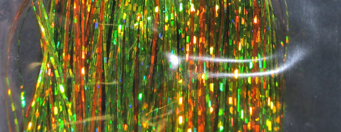 Holographic Flashabou tinsel strands in iridescent green and copper orange, thin reflective fly tying material