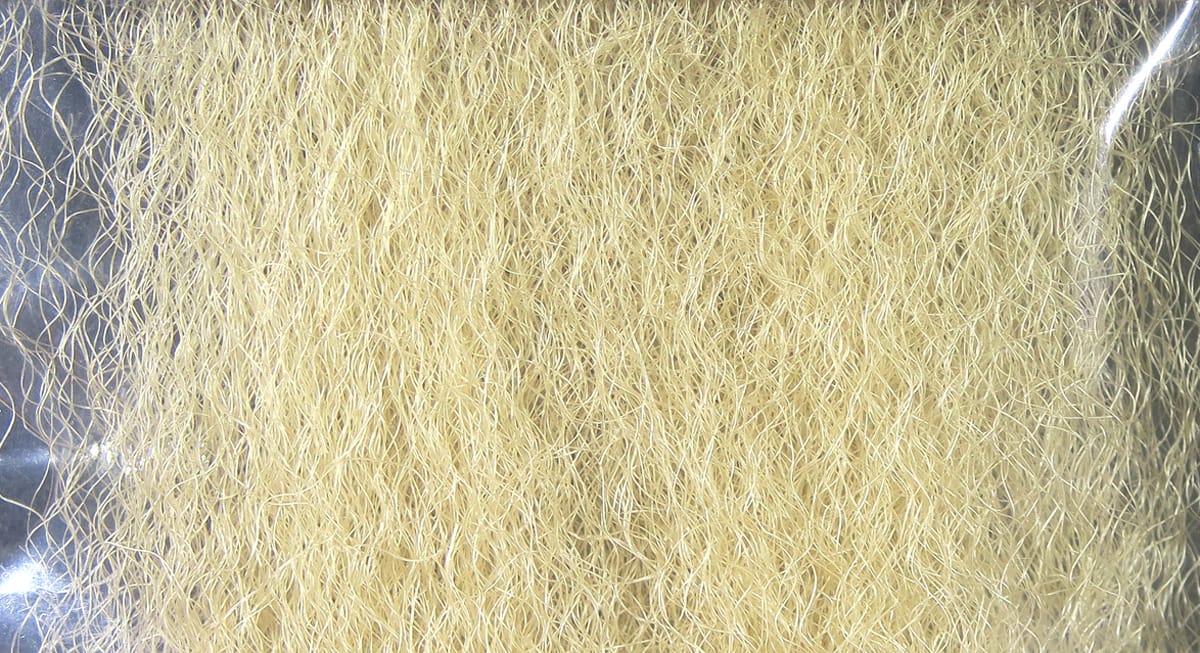 Pale tan Hedron strung fuzzy fiber bundle with curly, wispy synthetic strands for fly tying