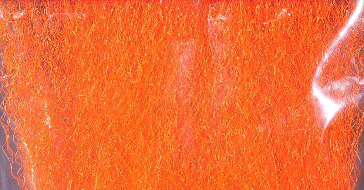 Bright fluorescent orange Hedron strung fuzzy fiber with fine iridescent strands, synthetic fly tying material