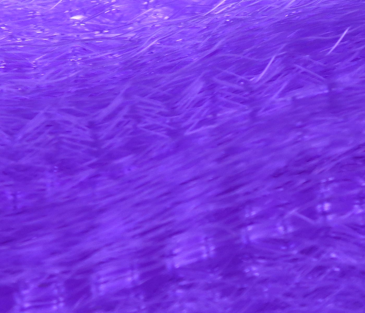 Vibrant purple synthetic fly tying hair close-up showing fine shiny strands and soft fluffy texture