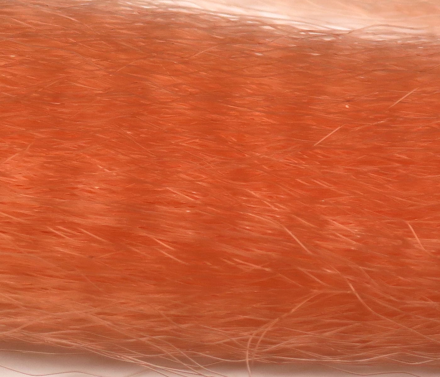 Bright orange synthetic fly tying hair with long fine translucent fibers, soft blended strands for streamers and tails