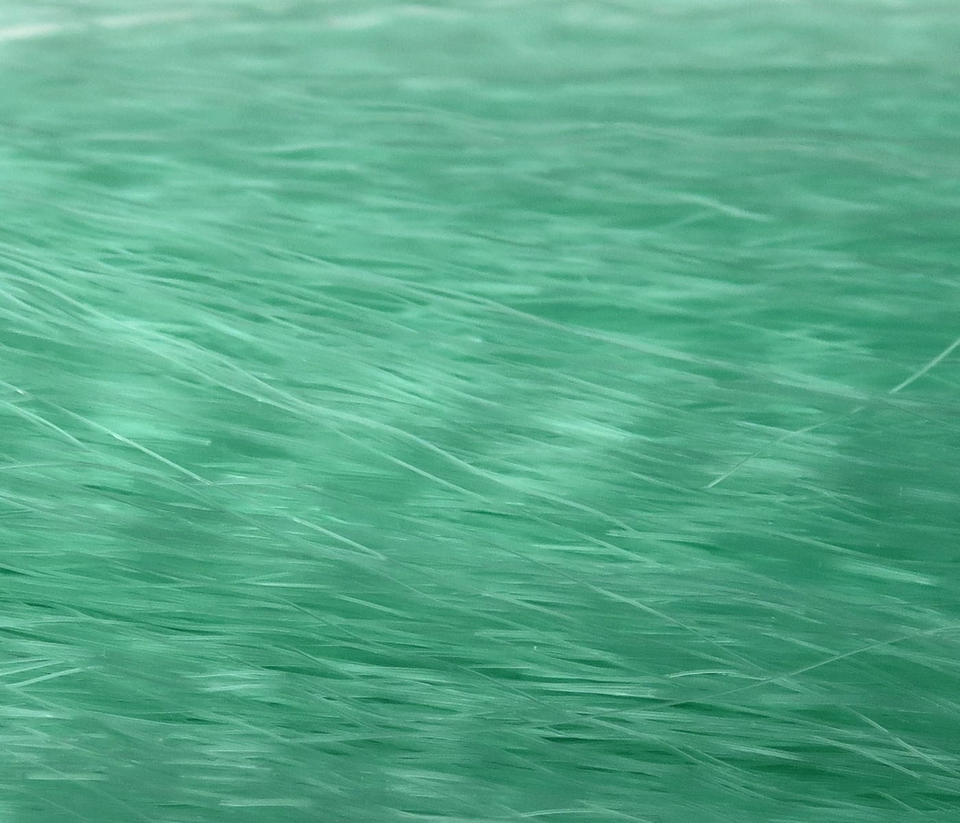 Mint green fly tying hair, fine silky synthetic strands with subtle sheen and layered texture