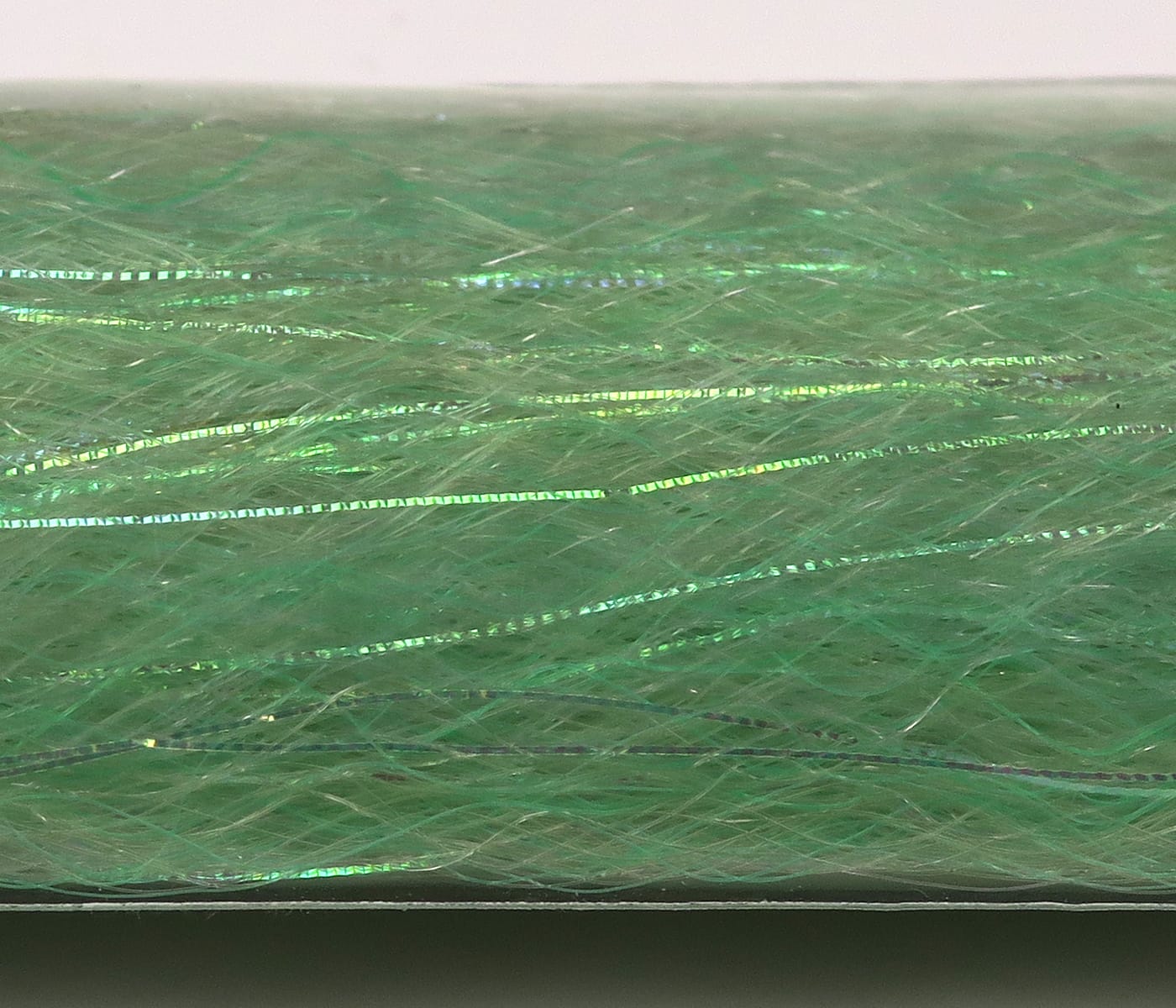 Green iridescent synthetic fibers with thin holographic flash strands for fly tying, soft slinky texture