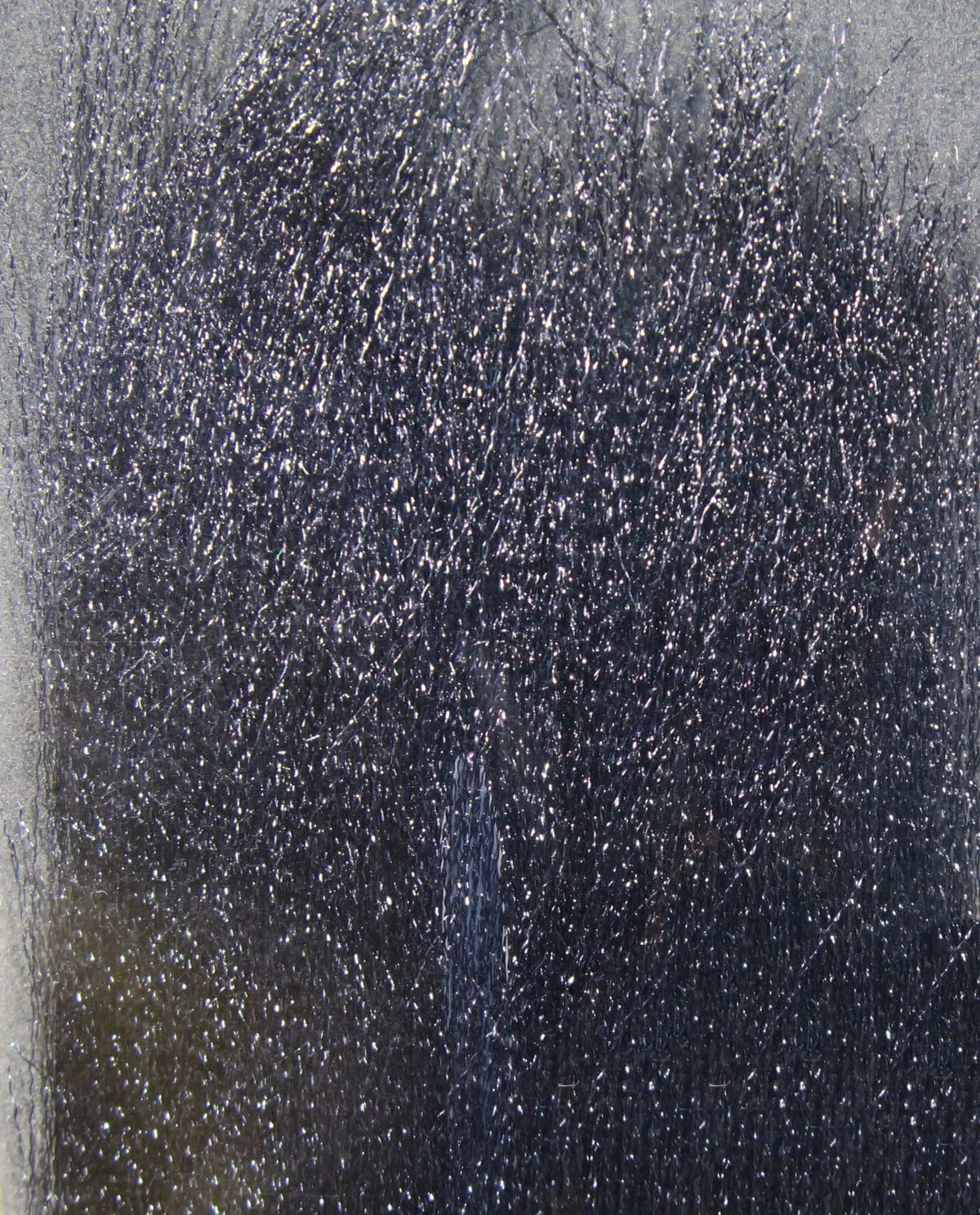 Dark charcoal fluoro fibre bundle with fine reflective strands and glittery iridescent sheen for fly tying.