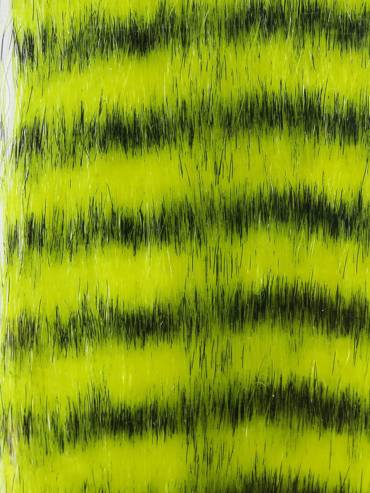 Chartreuse and black grizzly fibre with long synthetic strands and barred pattern for fly tying