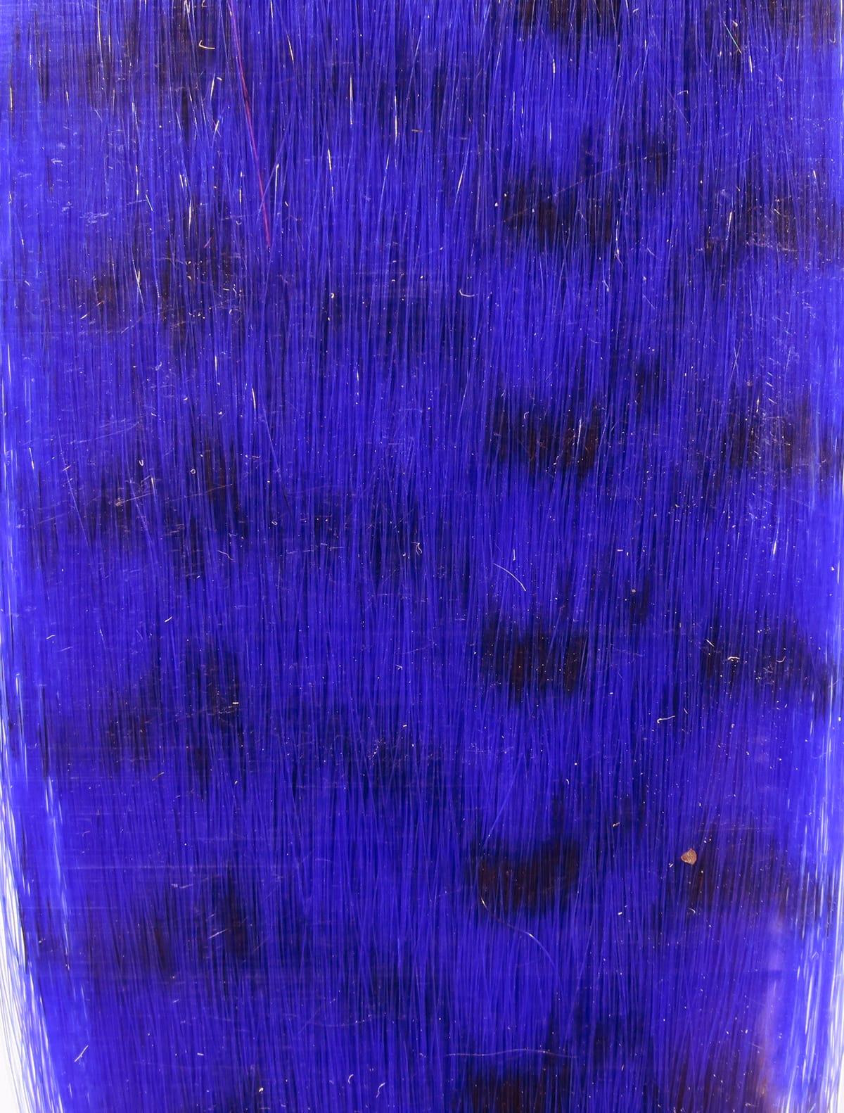 Deep violet synthetic grizzly fibre with long glossy strands and subtle darker mottled patches for fly tying