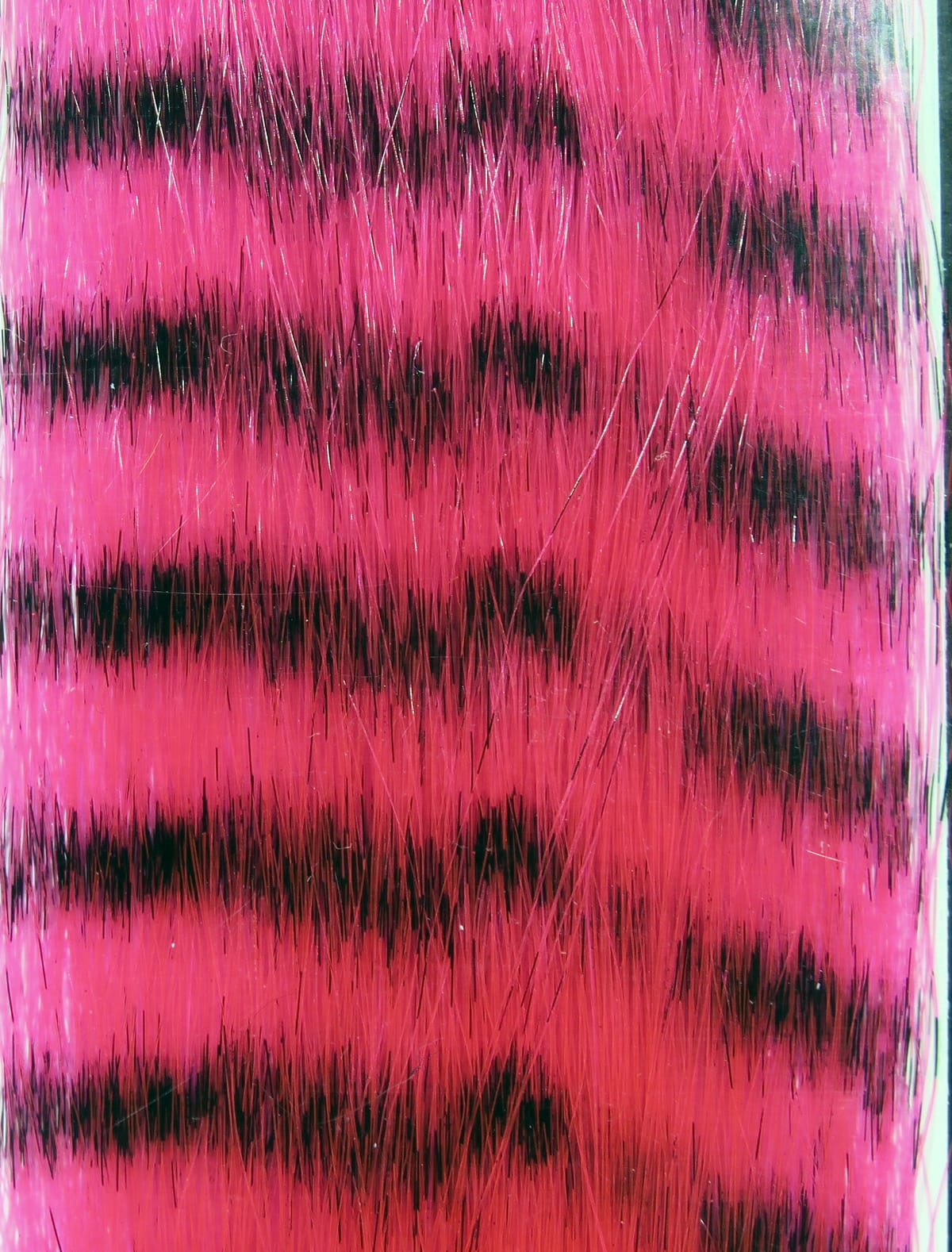 Hot pink and black barred synthetic grizzly fibre for fly tying, long glossy strands with contrasting black stripes