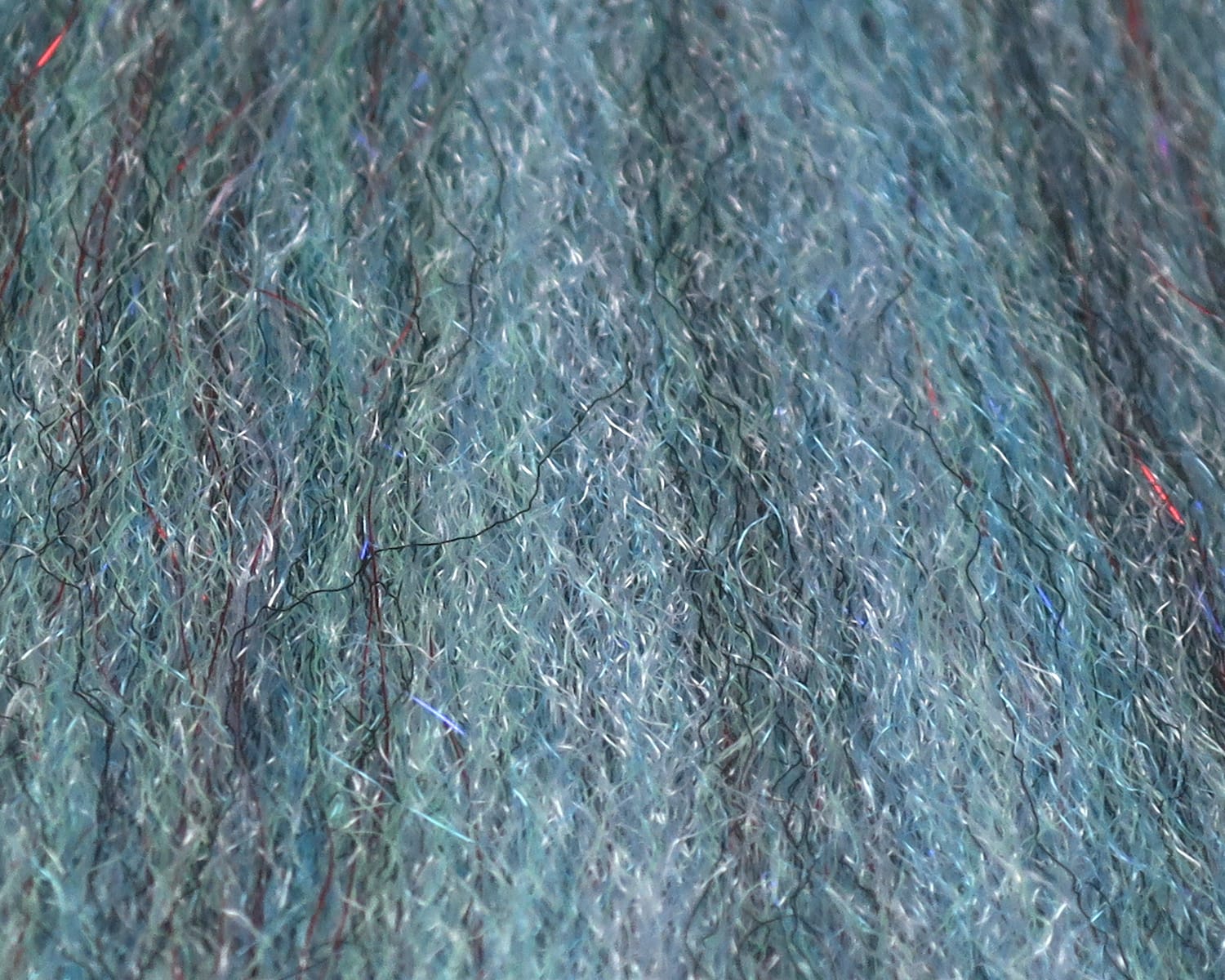 Teal-blue sculpting flash fibre with fine fuzzy synthetic strands and iridescent silver and red flashes for fly tying