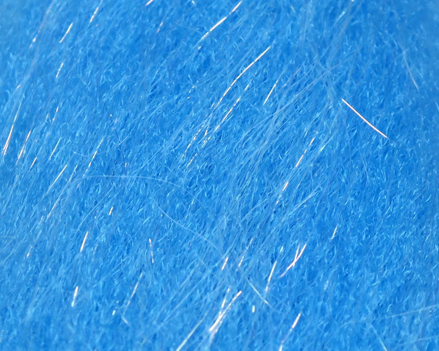 Bright blue synthetic sculpting flash fiber with fine iridescent strands, close-up texture for fly tying