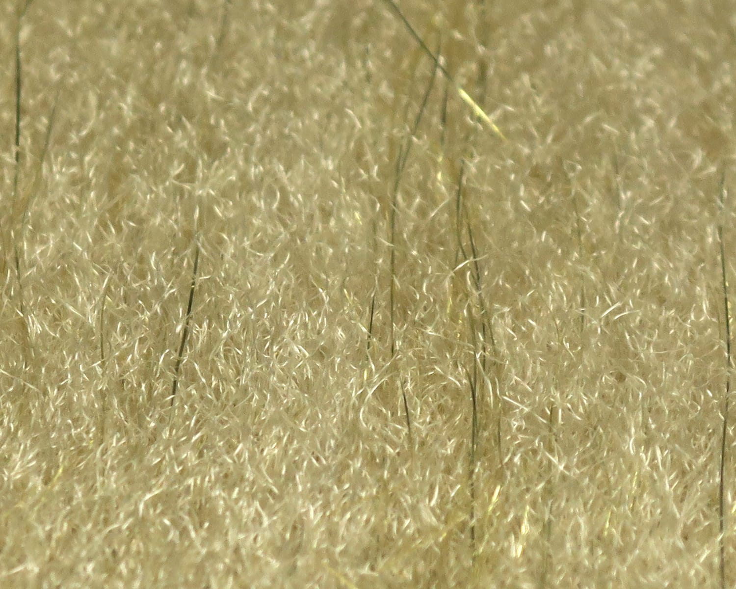 Tan sculpting flash fiber for fly tying with dense short synthetic fibers and scattered long olive shimmer strands