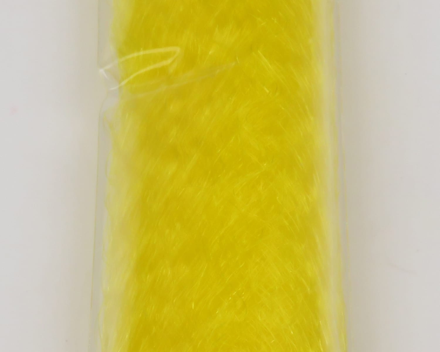Bright yellow synthetic slinky fibre for fly tying, wispy iridescent strands shown in clear plastic packaging