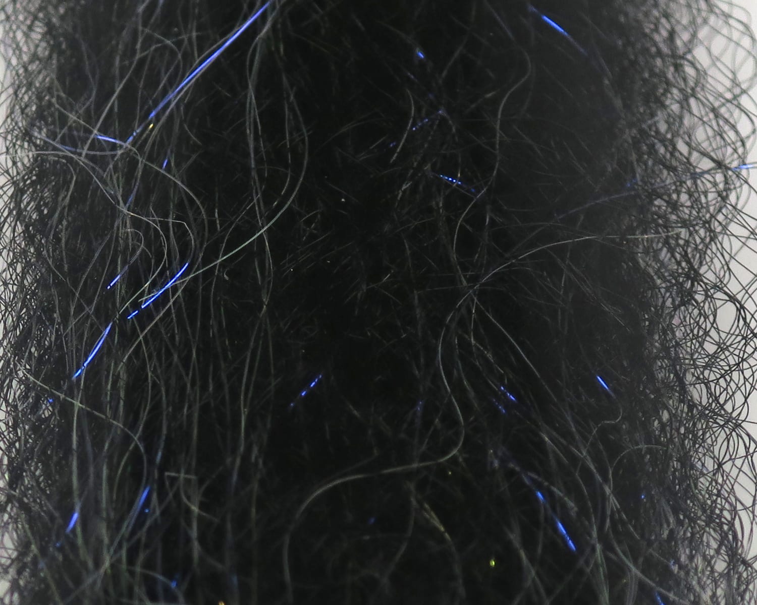 Black synthetic fly-tying dubbing with subtle blue flash strands, wispy tangled hair blend