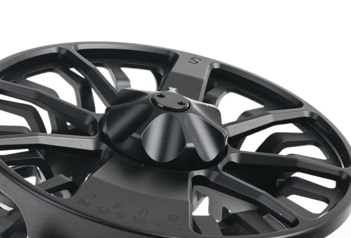 Matte black Lamson Guru S fly reel spool, machined anodized aluminum with skeletal spokes and low-profile drag knob