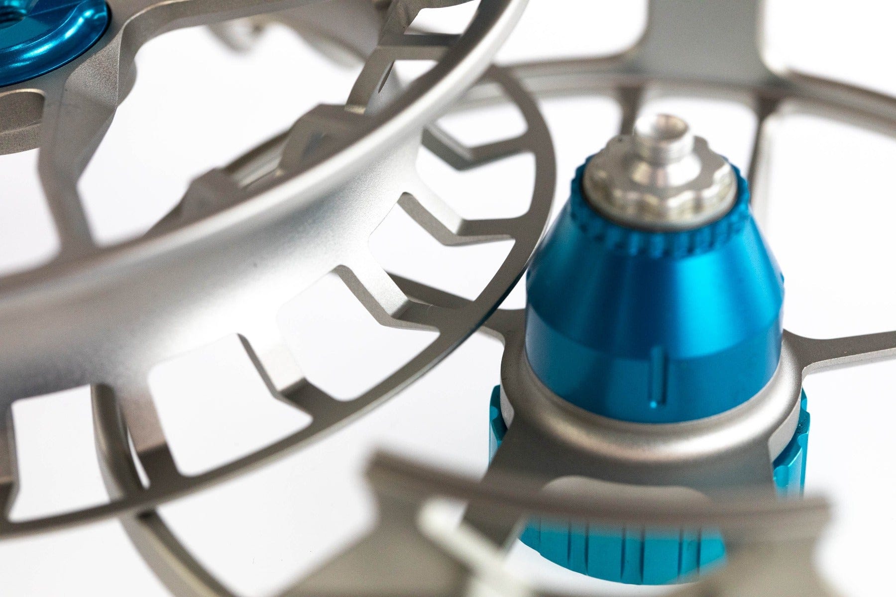 Close-up Lamson Litespeed M fly reel showing silver machined aluminum skeleton spool and blue anodized drag knob