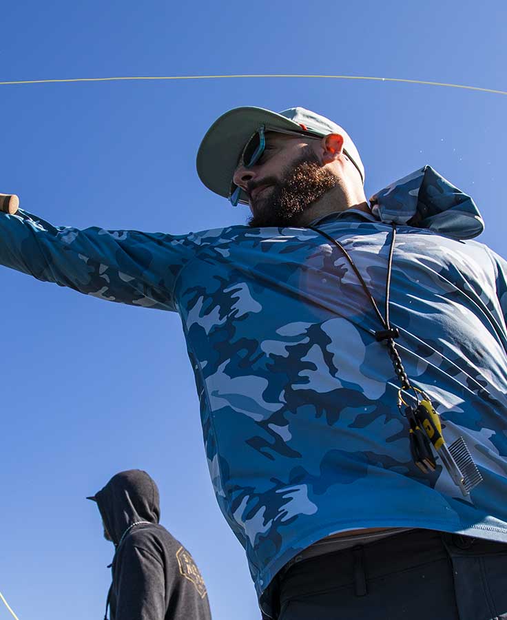 Black braided Loon Spartan lanyard with nippers and clip, worn by angler in blue camo hoodie and cap