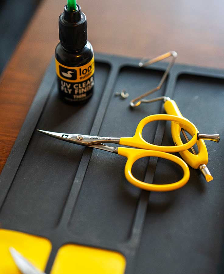 Loon yellow-handled tungsten carbide curved fly tying scissors with slim pointed blades on black mat