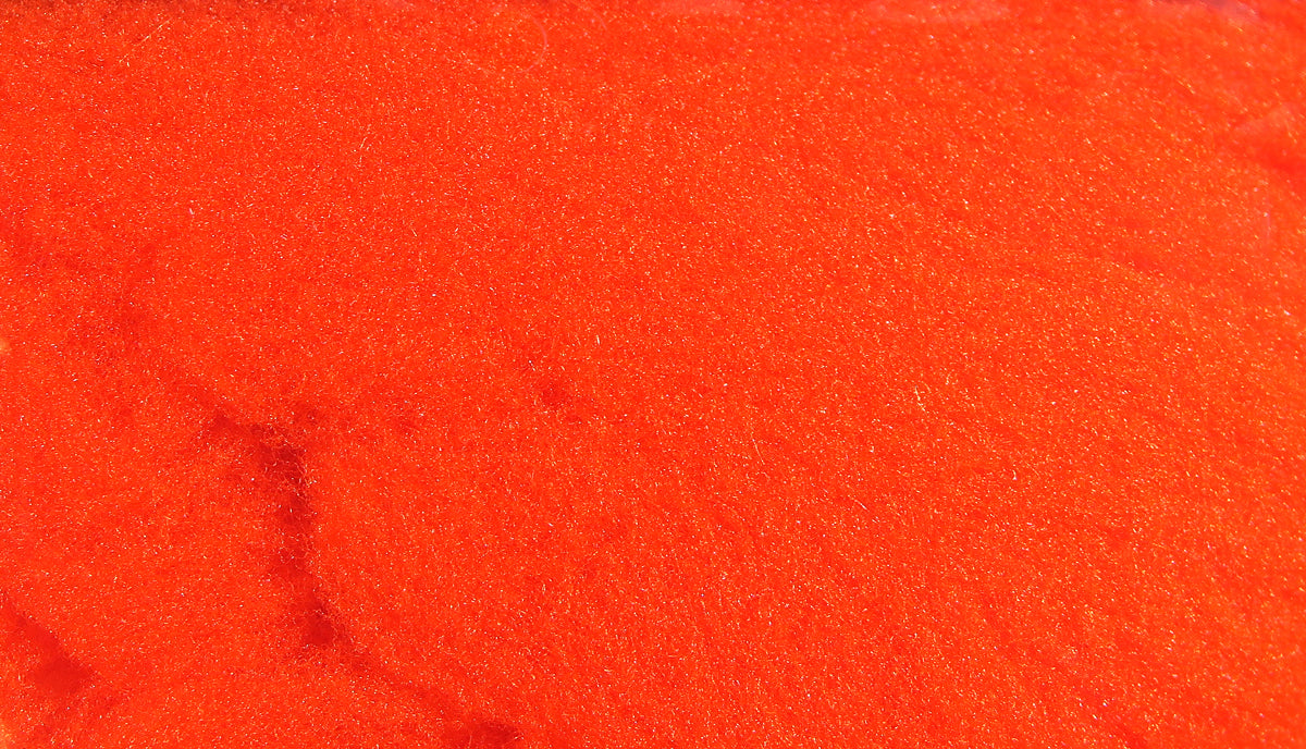Bright orange McFlyFoam fly tying yarn close-up showing fuzzy foam texture with subtle sparkle