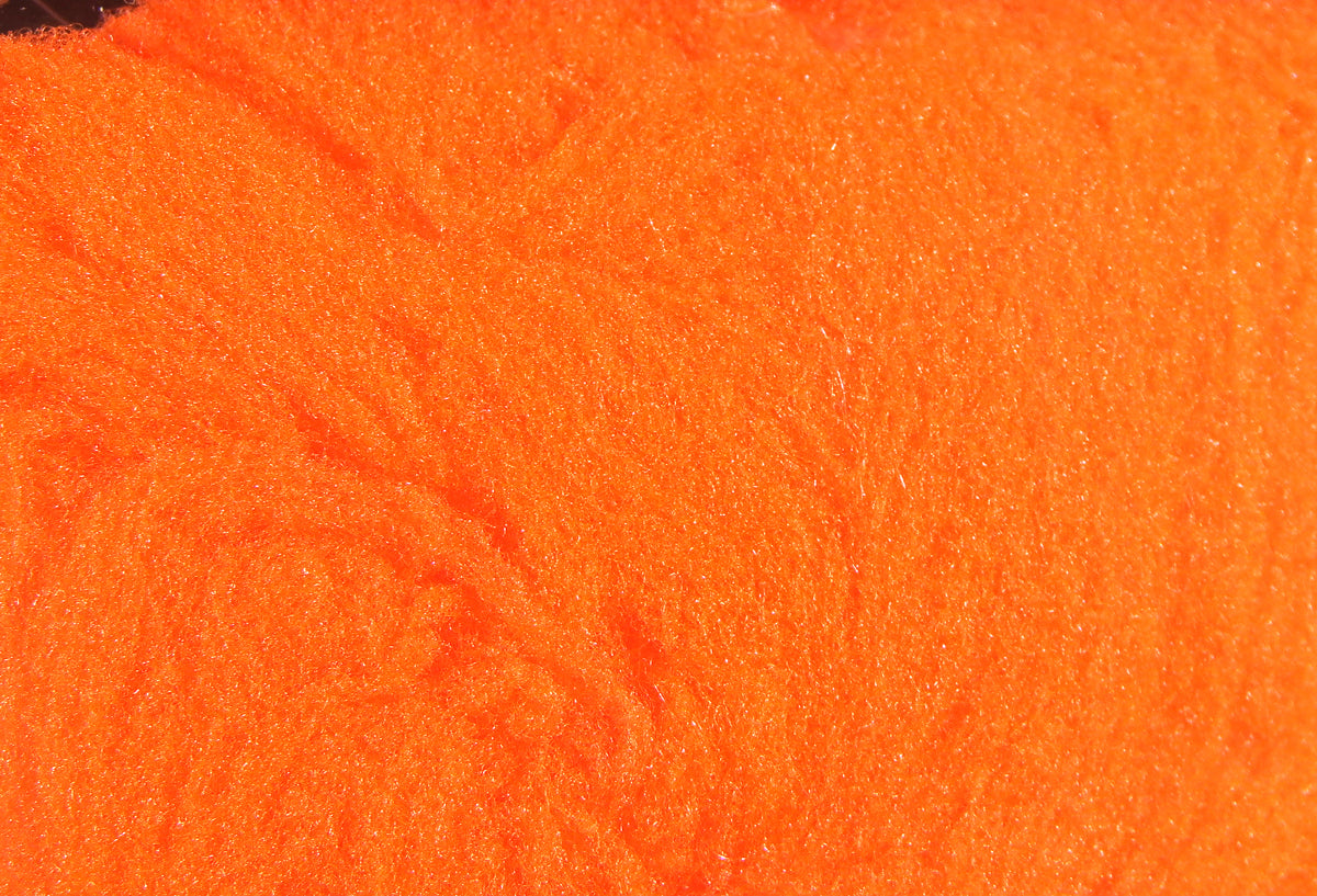 Bright neon orange fly tying yarn with fuzzy synthetic foam fibers and dense plush texture