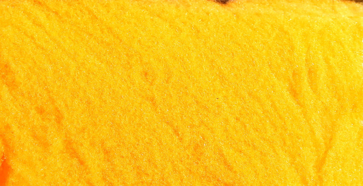 Bright yellow fly tying yarn close-up showing soft fibrous material texture for tying flies