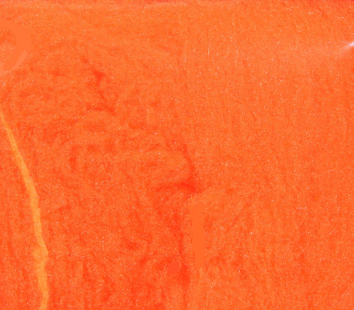Bright fluorescent orange McFlyFoam fly tying yarn with soft foam texture and subtle glittery fibers