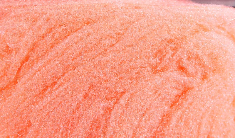 Peach-orange McFlyFoam fly tying yarn close-up showing shimmery synthetic foam fibers with textured, fluffy strands