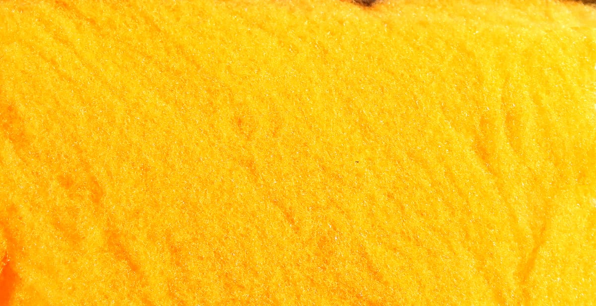 Bright yellow fly tying yarn close-up showing soft fibrous material texture for tying flies