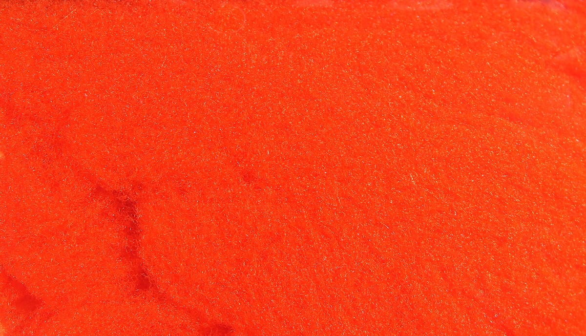 Bright orange McFlyFoam fly tying yarn close-up showing fuzzy foam texture with subtle sparkle