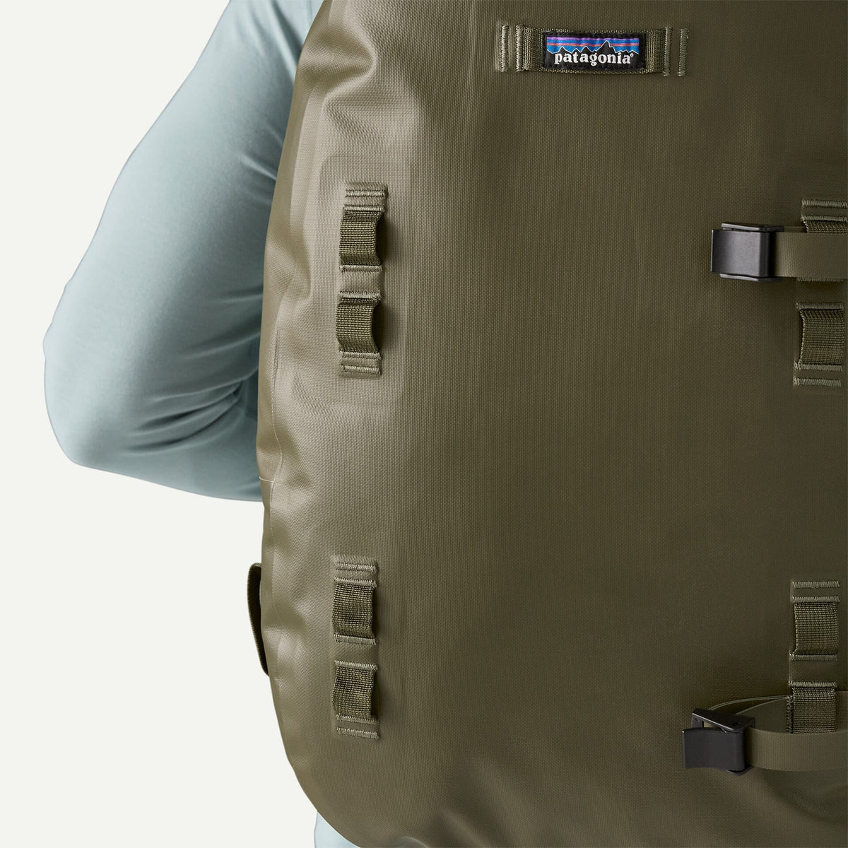 Olive green Patagonia Guidewater backpack with waterproof coated fabric, webbing lash points, black buckle and logo patch