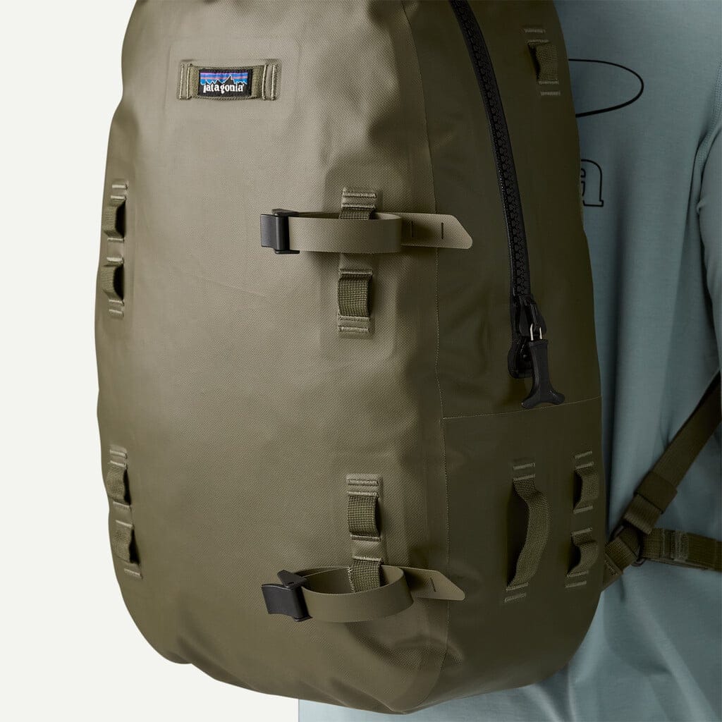 Olive green Patagonia Guidewater backpack in durable waterproof fabric with side zipper, compression straps, logo patch