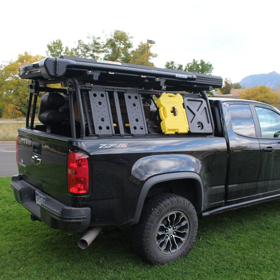 Black truck bed rack system with yellow quick release mount and storage accessories for fishing rod organization