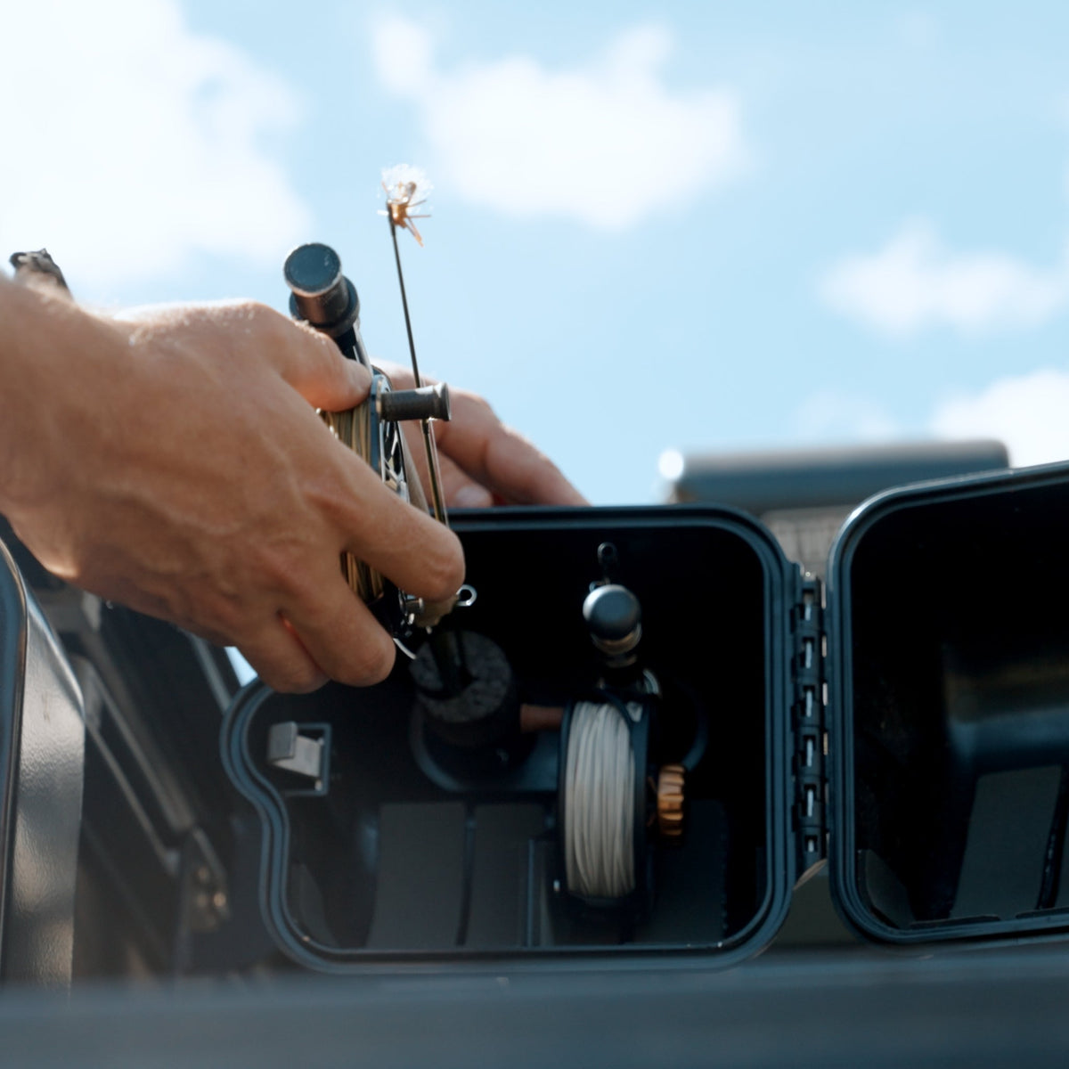 Riversmith Truck Bed River Quiver fishing rod holder mounted on vehicle with cotton flower detail and blue accent trim