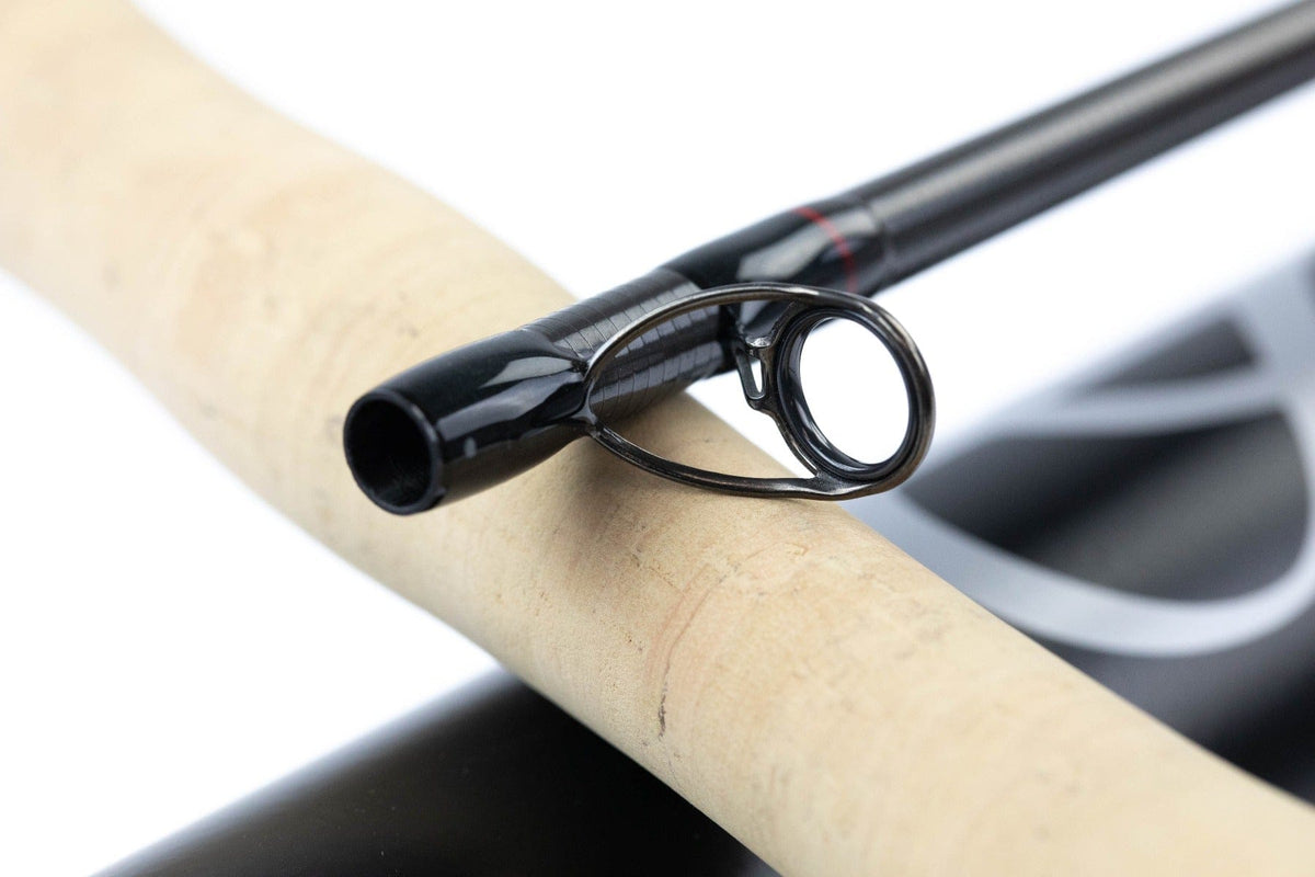 Scott Centric black graphite fly rod close-up showing glossy blank, dark metal guide ring and natural cork handle