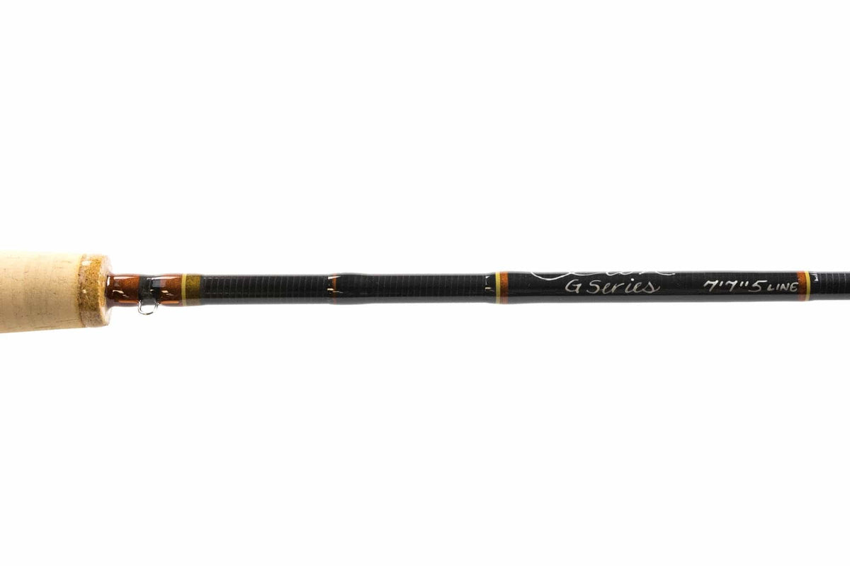 Scott G Series black graphite fly rod section with cork handle, orange-gold wraps, silver guide and white G Series script