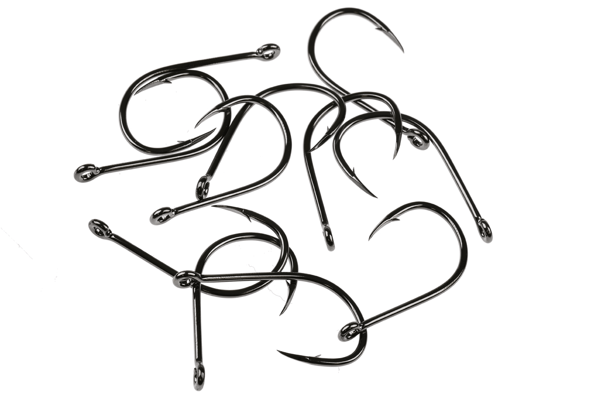 Black nickel Tiemco TMC 600SP heavy saltwater fly hooks scattered on a white background, showing curved shanks, sharp
