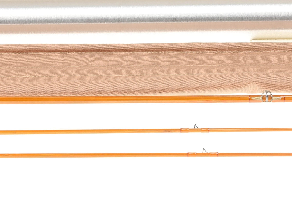 H.L. Leonard Centennial orange bamboo fly rod sections with silver guides laid above tan fabric sleeve and aluminum tube