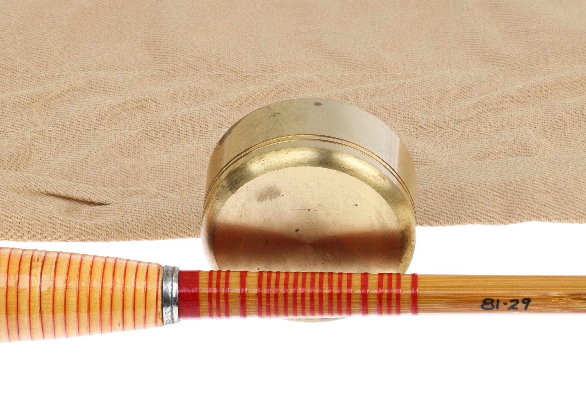 Antique H.L. Leonard bamboo fly rod section with red-striped grip and brass butt cap
