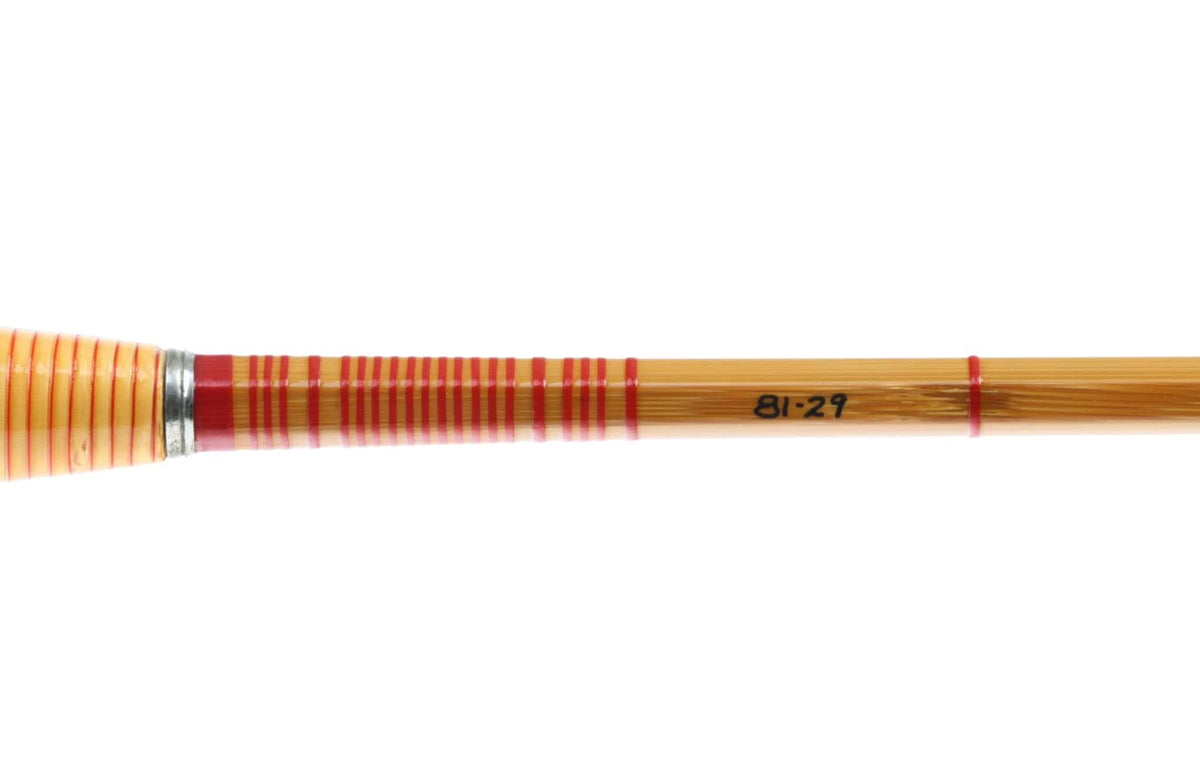 Amber bamboo fly rod section with red thread wraps, cork handle, nickel silver winding check and black 81-29 marking