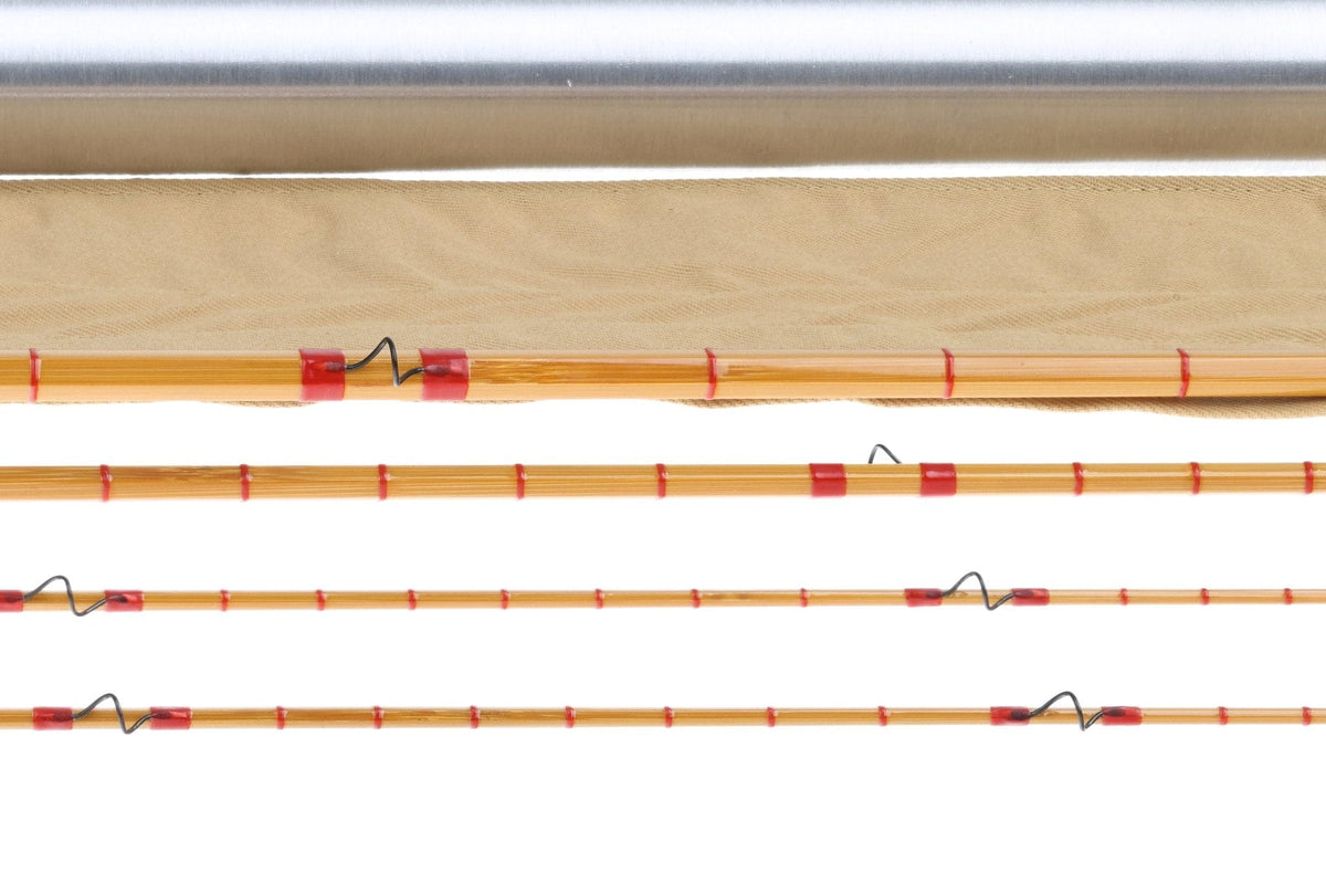 Amber bamboo fly rod sections with red thread wraps, black wire guides and canvas sleeve, H.L. Leonard Centennial 8ft 6in 5wt